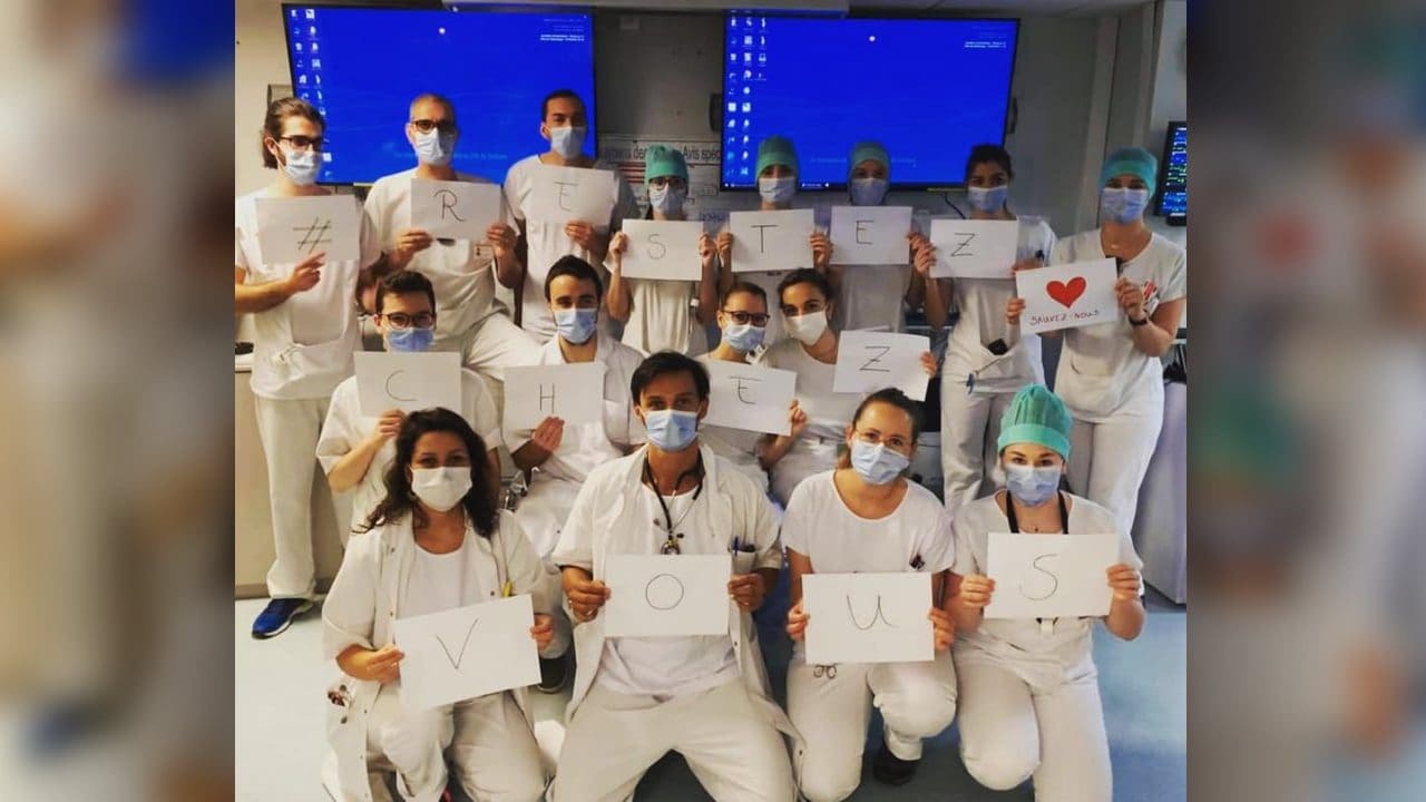 Médecins et infirmières - mensaje RESTEZ CHEZ VOUS adressé au public «Je suis resté au travail pour vous. Vous restez à la maison pour nous ”