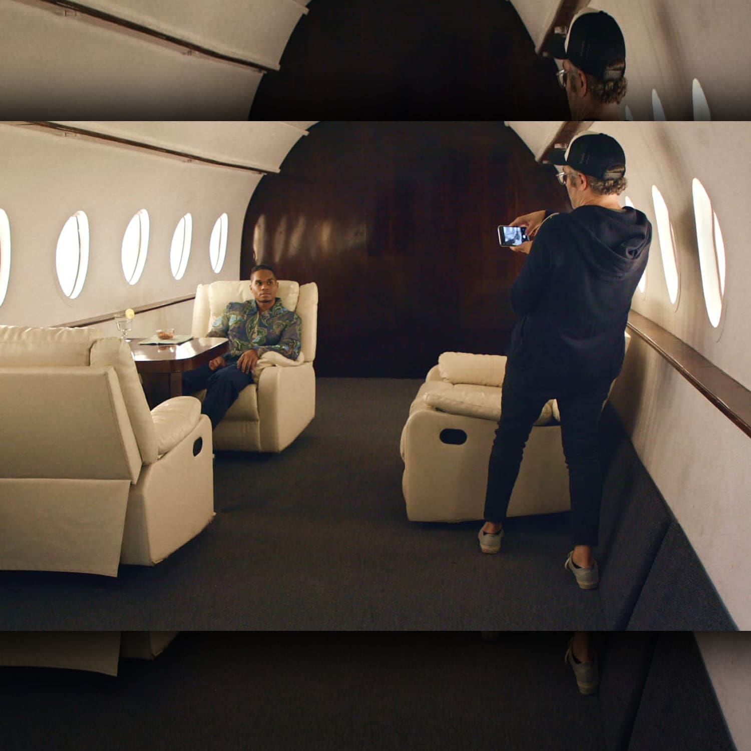 Journalist Nick Bilton takes a photo of Chris Bailey on a fake private plane set for the HBO documentary “Fake Famous.”Source: HBO