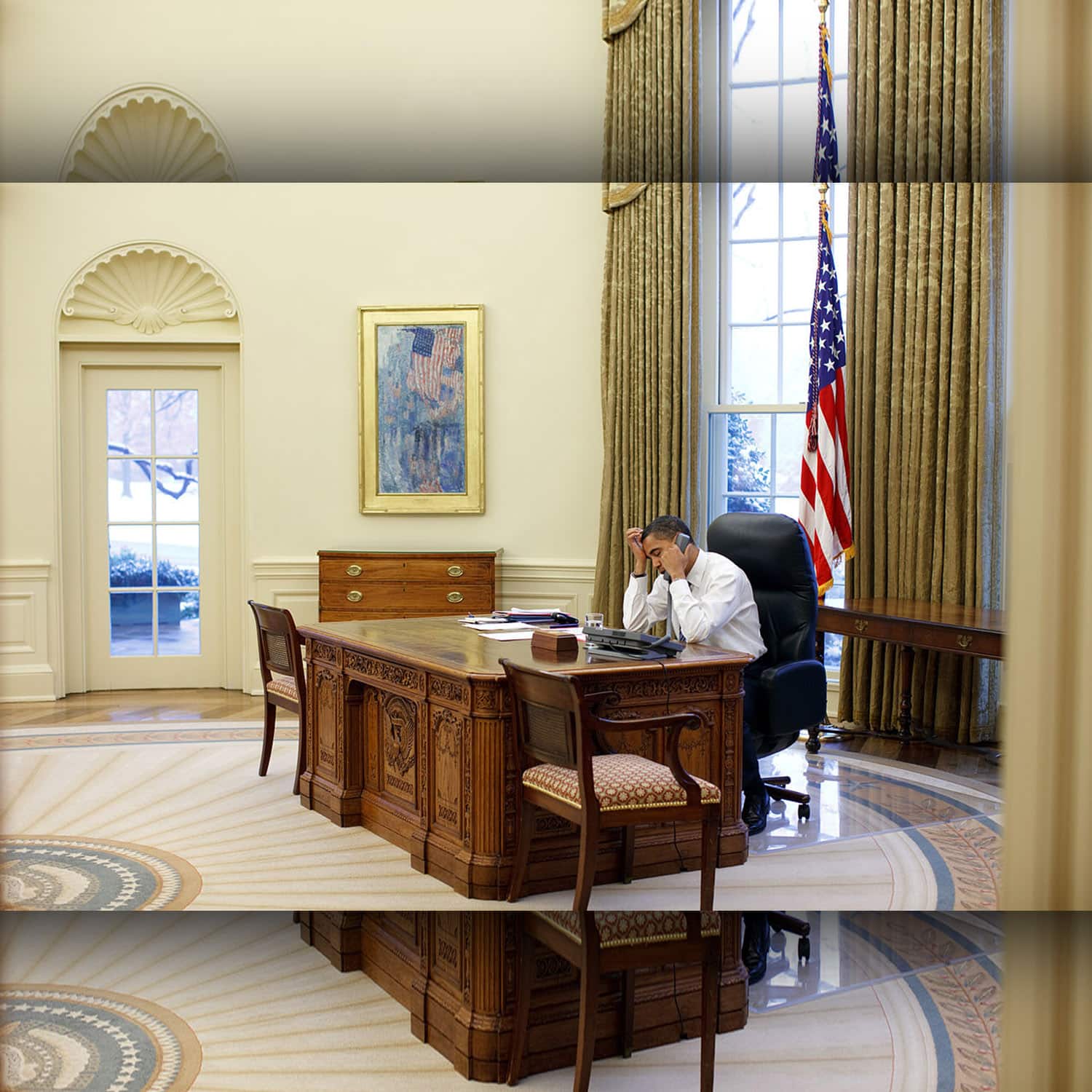 Barak Obama working at his desk in the Oval Office